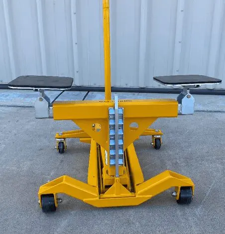 A yellow machine with two metal seats on it.