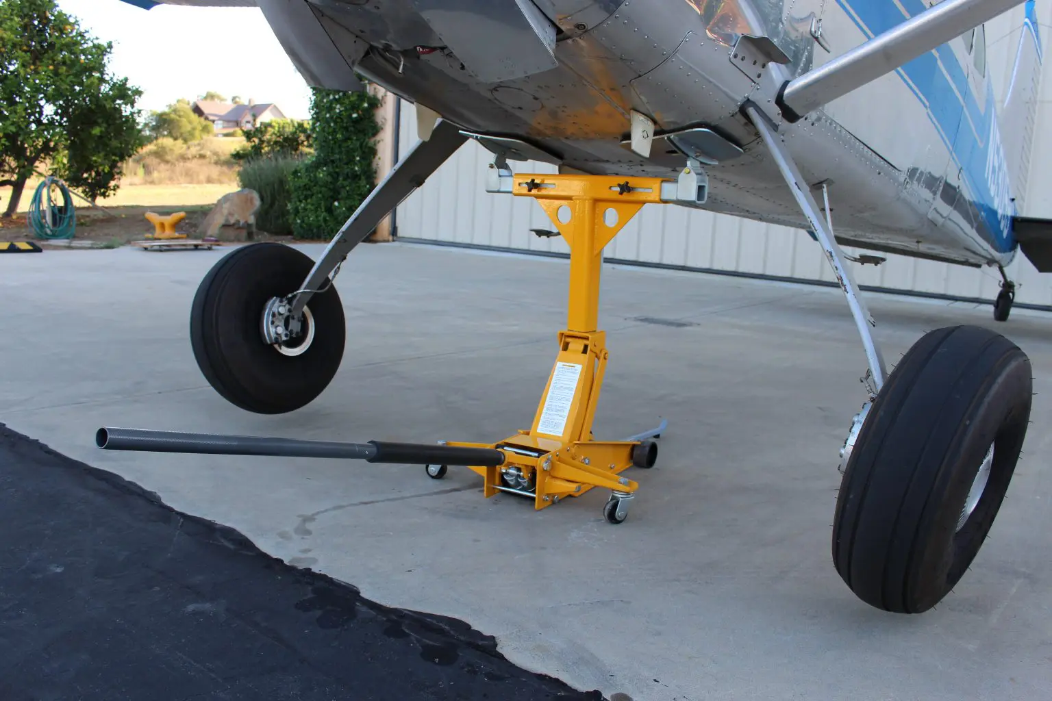 A yellow airplane is parked on the concrete.